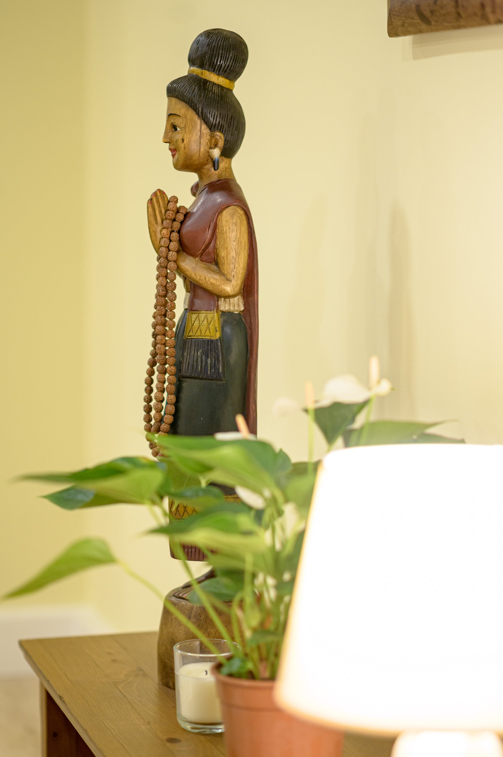 Estatua budista con plantas y lámpara